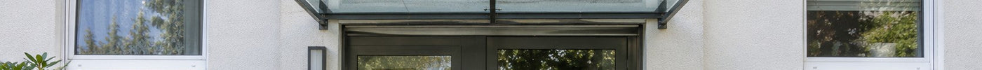 Vordach aus Glas über dem gemeinsamen Hauseingang eines Mehrfamilienhauses – Deutsche Kunststoffbedachungen