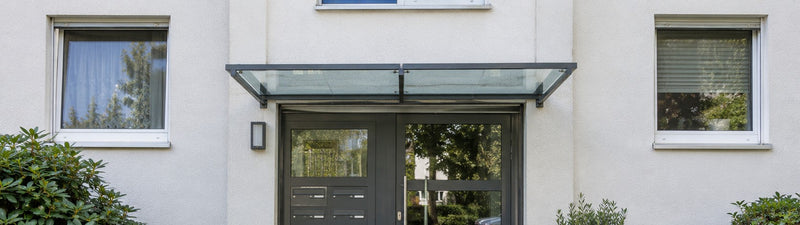 Vordach aus Glas über dem gemeinsamen Hauseingang eines Mehrfamilienhauses – Deutsche Kunststoffbedachungen