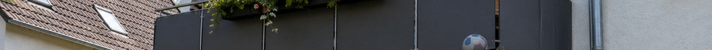Balkonbrüstung mit robusten HPL-Balkonplatten in Anthrazit und Blumenkasten an einem Wohnhaus – Deutsche Kunststoffbedachungen
