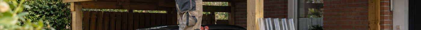 Heimwerker verschraubt klare Wellplatten auf dem Holz-Carport vor einem Klinkerhaus – Deutsche Kunststoffbedachungen