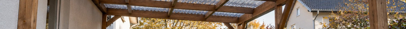 Holz-Carport mit klaren Wellplatten, an deren Unterseite sich am Herbstmorgen Kondenswasser bildet – Deutsche Kunststoffbedachungen